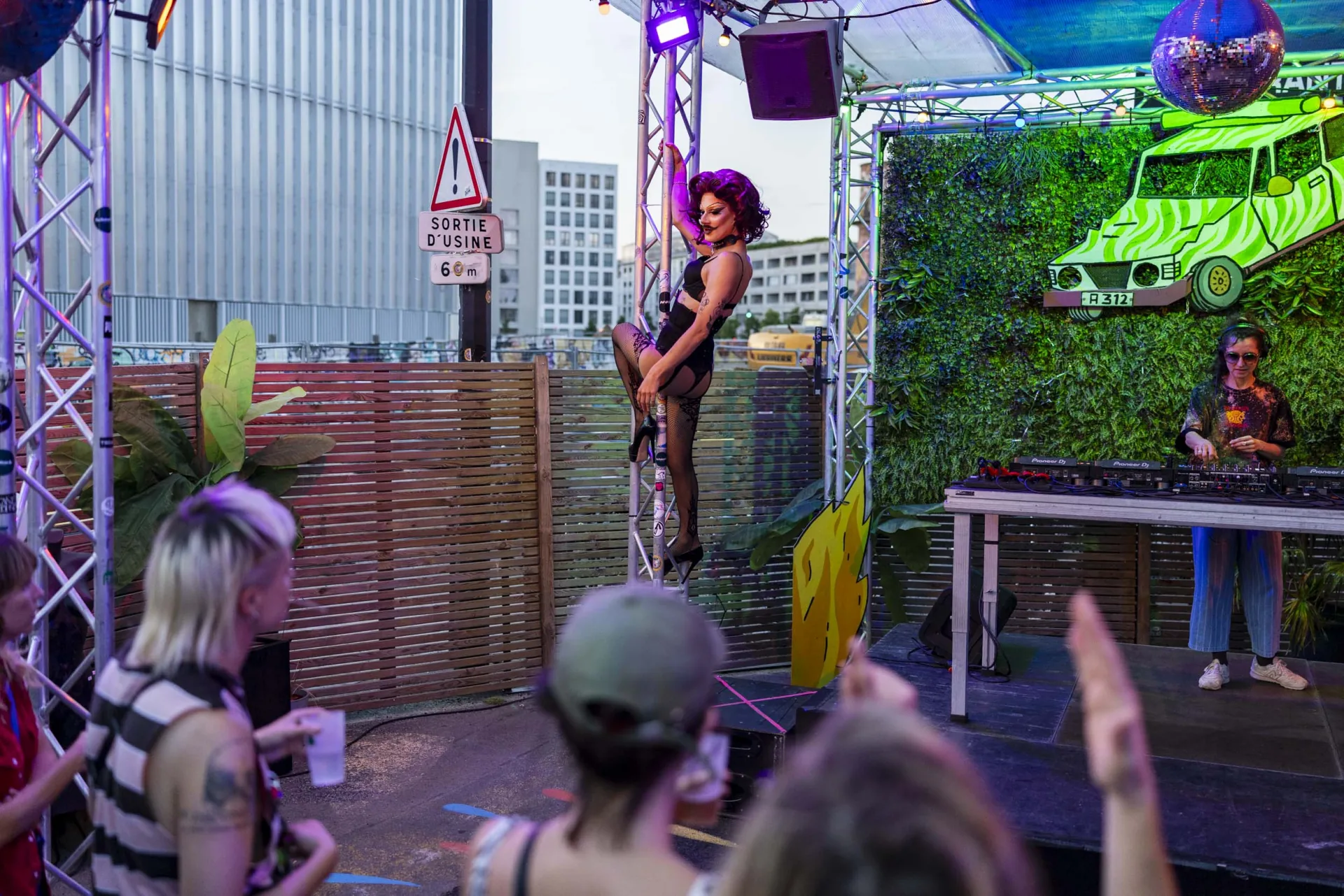 Performance drag sur barre et DJ set dans le patio au crépuscule